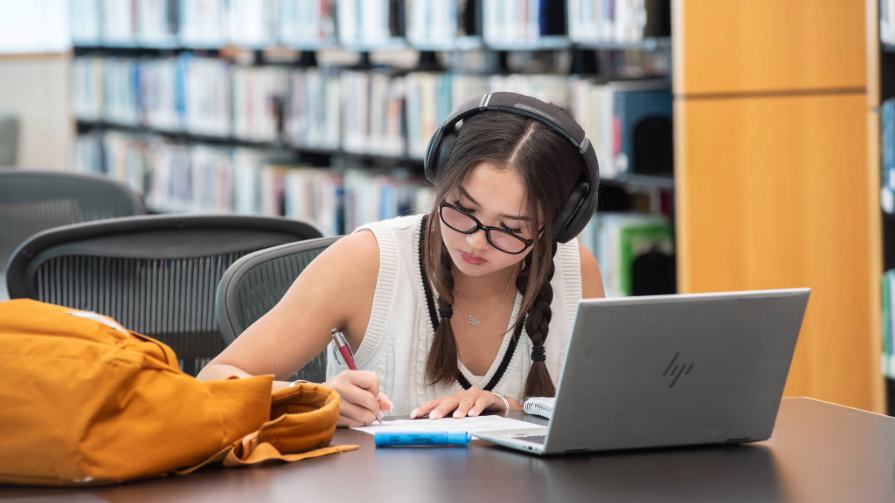 Woman studying in 91AV's university library.